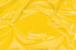 Wrinkled cling film, plastic texture, vinyl background. Yellow overlay for mockup. Abstract, art design layout.
