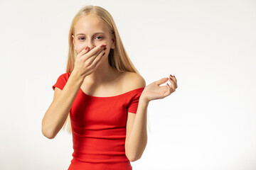 Teenage girl with blond hair and in a red dress sneezes