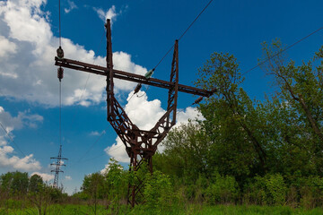 Old metal power line tower on cloudy sky background