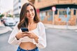 © Krakenimages.com - Young hispanic woman smiling happy using smartphone at the city.