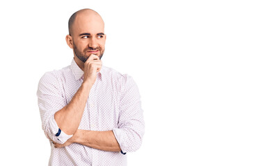 Wall Mural - Young handsome man wearing elegant shirt with hand on chin thinking about question, pensive expression. smiling with thoughtful face. doubt concept.