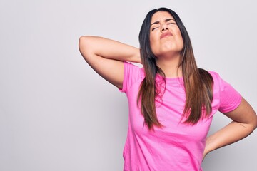 Poster - Young beautiful brunette woman wearing casual pink t-shirt standing over white background Suffering of neck ache injury, touching neck with hand, muscular pain