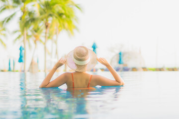 Portrait beautiful young asian woman relax smile leisure around outdoor swimming pool nearly sea beach ocean