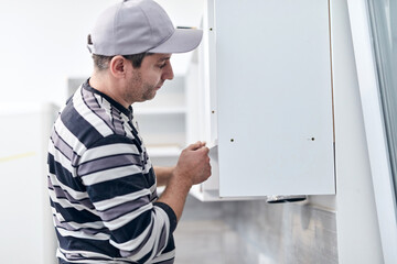 Wall Mural - Handyman worker fixing and assembling household furniture.