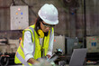 © visoot - Female Industrial Worker using laptop work at the heavy industry manufacturing facility.