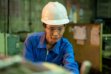 Aufkleber - Female technician in blue workwear and helmet working at factory.