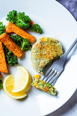 Wall Mural - Vegetarian food concept. Vegetable fritter with baked sweet potato and kale on white plate, top view.