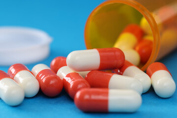 Sticker - Many medical capsules spilling out of medicine jar closeup