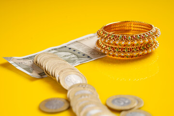 New Indian five hundred rupees note,coins and gold jewelry over yellow background