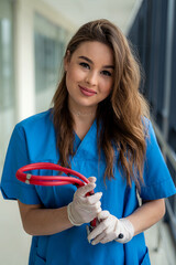 Wall Mural - Young sexy nurse or femele doctor in blue uniform posing on modern hallway clinic