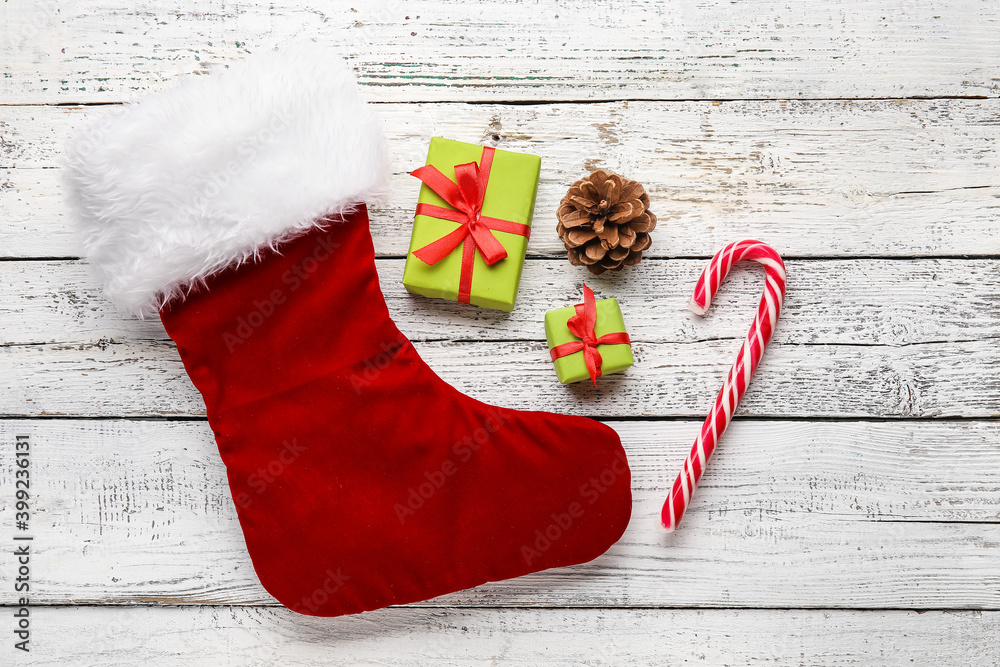 Composition with Christmas sock on white wooden background