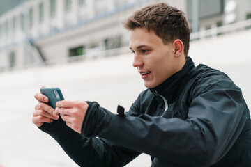 attractive young sportsman using mobile phone