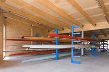Rowing Sculls Or Boats Stored On Rack In Boathouse. 