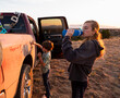 © Mint Images - Two children painting the side of an old pickup truck