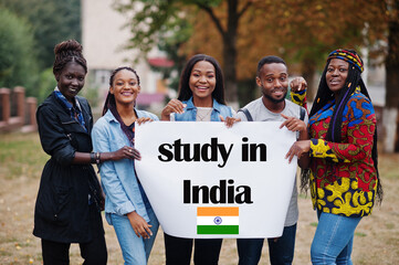 Wall Mural - Study in India. Group of five african college students on campus at university yard hold white blank. Abroad countries for student concept.