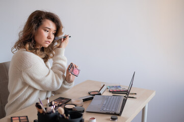 Online training for make-up. A woman teacher explains the makeup application scheme on the air