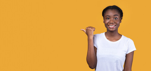 Aufkleber - Black Woman Pointing Thumb Aside At Copy Space, Yellow Background