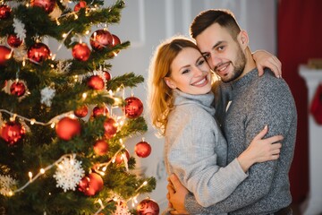 Romantic couple in love feeling happiness about their romance spending christmas eve together, woman and man enjoying perfect relationships and spending winter vacations in cozy home interior