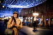 © BGStock72 - Pretty young woman using her mobile phone in the street at Christmas time