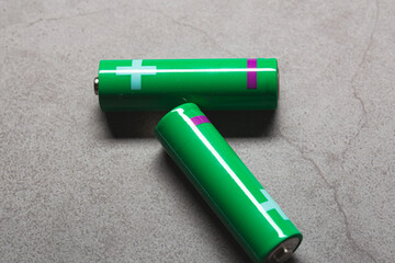 Green old alkaline batteries on a grey background