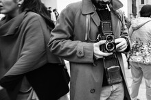 Hipster Guy With The Vintage Camera Photographing People In The City - Photojournalist With A Famous Retro Camera Taking Photo In The Crowd During Street Demonstration - Street Photography Style 