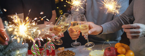 Champagne in hand against the background of the Christmas tree. People. Selective focus.