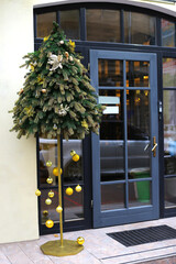 Wall Mural - Christmas tree with golden balls in front of the entrance door. Christmas outdoor decoration