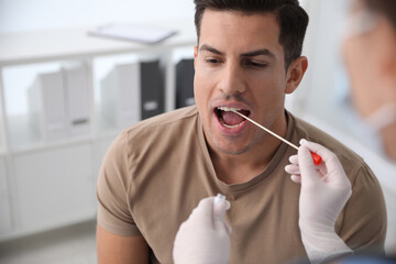 Canvas Print - Doctor taking sample for DNA test from man in clinic