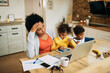 © Drazen - African American single mother feeling stressed out while working at home.