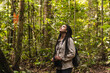 © KIKE ARNAIZ/Stocksy - Girl with braids in the middle of the forest with binoculars