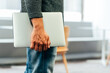 © David Prado/Stocksy - Unrecognizable businessman with laptop at office