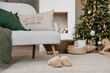 © Alina Hvostikova/Stocksy - Sofa and slippers in cozy living room on Christmas Day