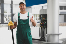 Worker With Fuel Pump Nozzle At Modern Gas Station