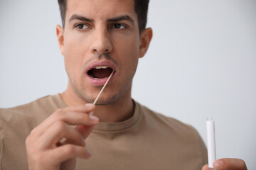 man taking sample for dna test on light background