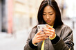 © Santi Nunez/Stocksy - Chinese woman looking at her smartphone.