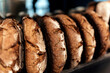 © Santi Nunez/Stocksy - Loaves of bread lined up on metal shelves.