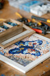 © Alina Hvostikova/Stocksy - Butterfly mosaic on table in workshop