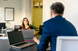 © JOSEP M ROVIROSA/Westend61 - Businessman discussing strategy with businesswoman at office desk