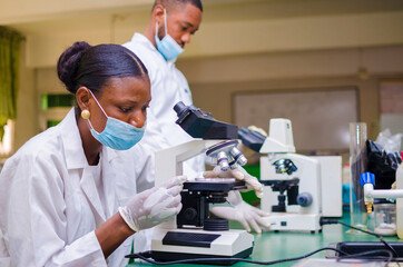 two young african health care researchers working in life science laboratory about the cure of the outbreak in the society.