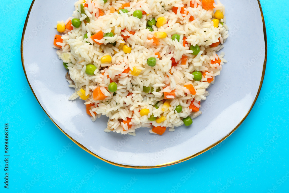 Plate with tasty pilaf on color background
