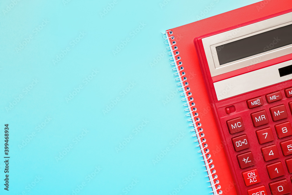 Digital calculator and notebook on color background