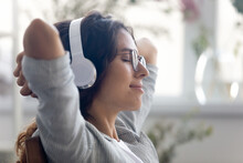 Catching Inspiration. Close Up Of Pretty Young Lady Sitting On Chair In Modern Multimedia Device Headphone Set On Head. Millennial Woman Rest With Closed Eyes Listen To Music Audiobook Study Language