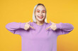 © ViDi Studio - Smiling fun young blonde caucasian woman 20s wearing casual basic purple shirt pointing index finger on sweatshirt looking camera toothy smile isolated on yellow color background studio portrait.