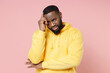 © ViDi Studio - Confused worried young african american man 20s wearing casual basic yellow streetwear hoodie standing put hand on head looking camera isolated on pastel pink color wall background studio portrait.