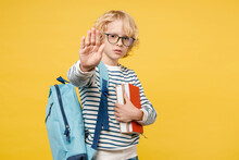 Serious Little Male Kid Teen Boy 10s In Striped Sweatshirt Eyeglasses Backpack Hold School Books Showing Stop Gesture With Palm Isolated On Yellow Background Child Studio Portrait. Education Concept.