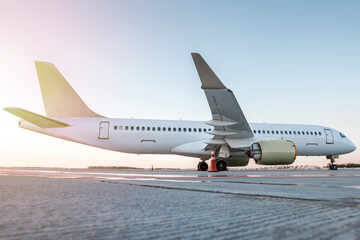 Modern passenger airliner on the airport apron in the sun light