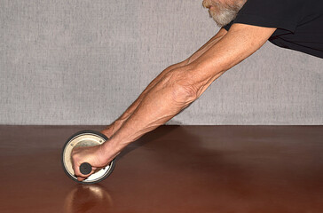 Male hands hold abdominal exercise wheel