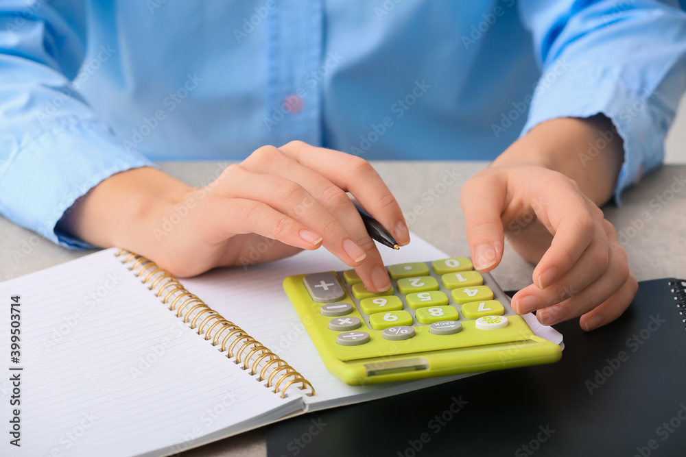 Female accountant with calculator working in office, closeup