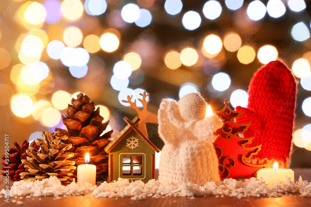 Christmas composition with decor and candles on table against blurred lights