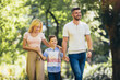 © Mediteraneo - Young happy family with one children in the summer park